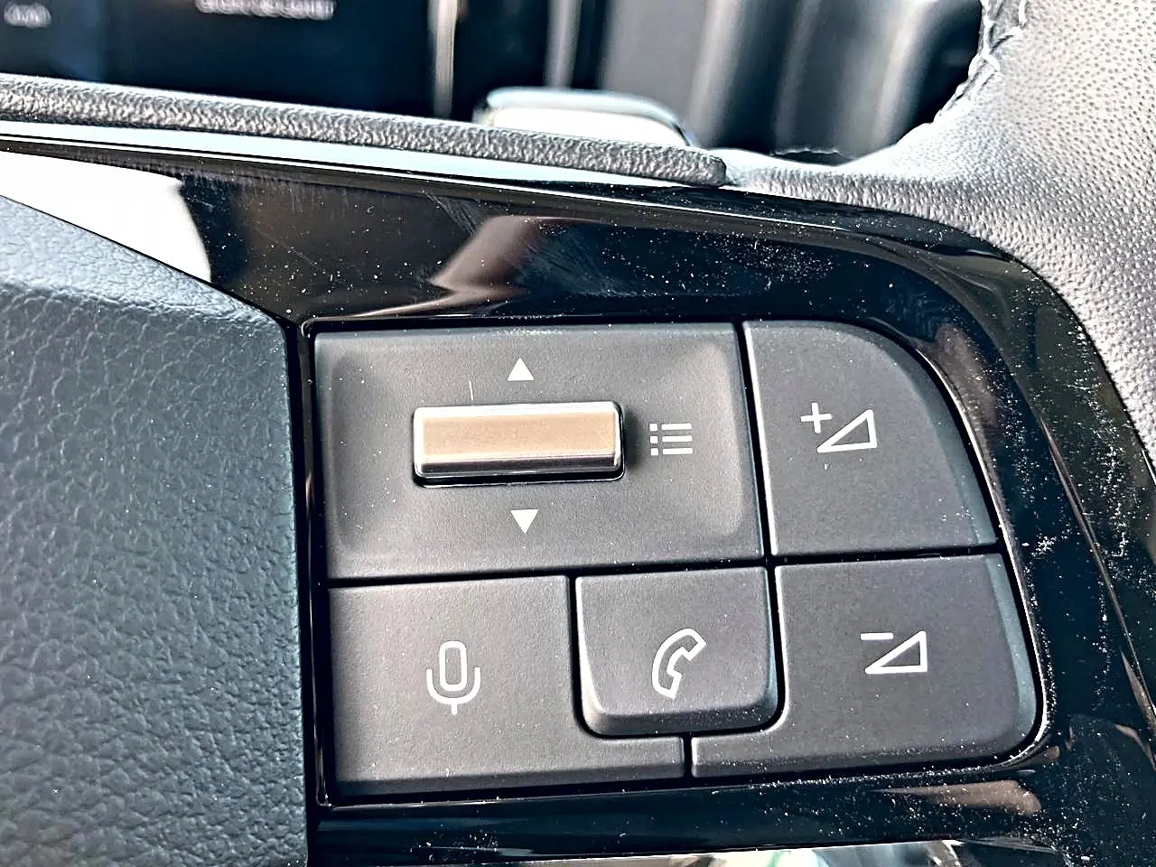 Gros plan sur les commandes audio et vocales noires sur le volant du Citroën Berlingo noir, version 2026.