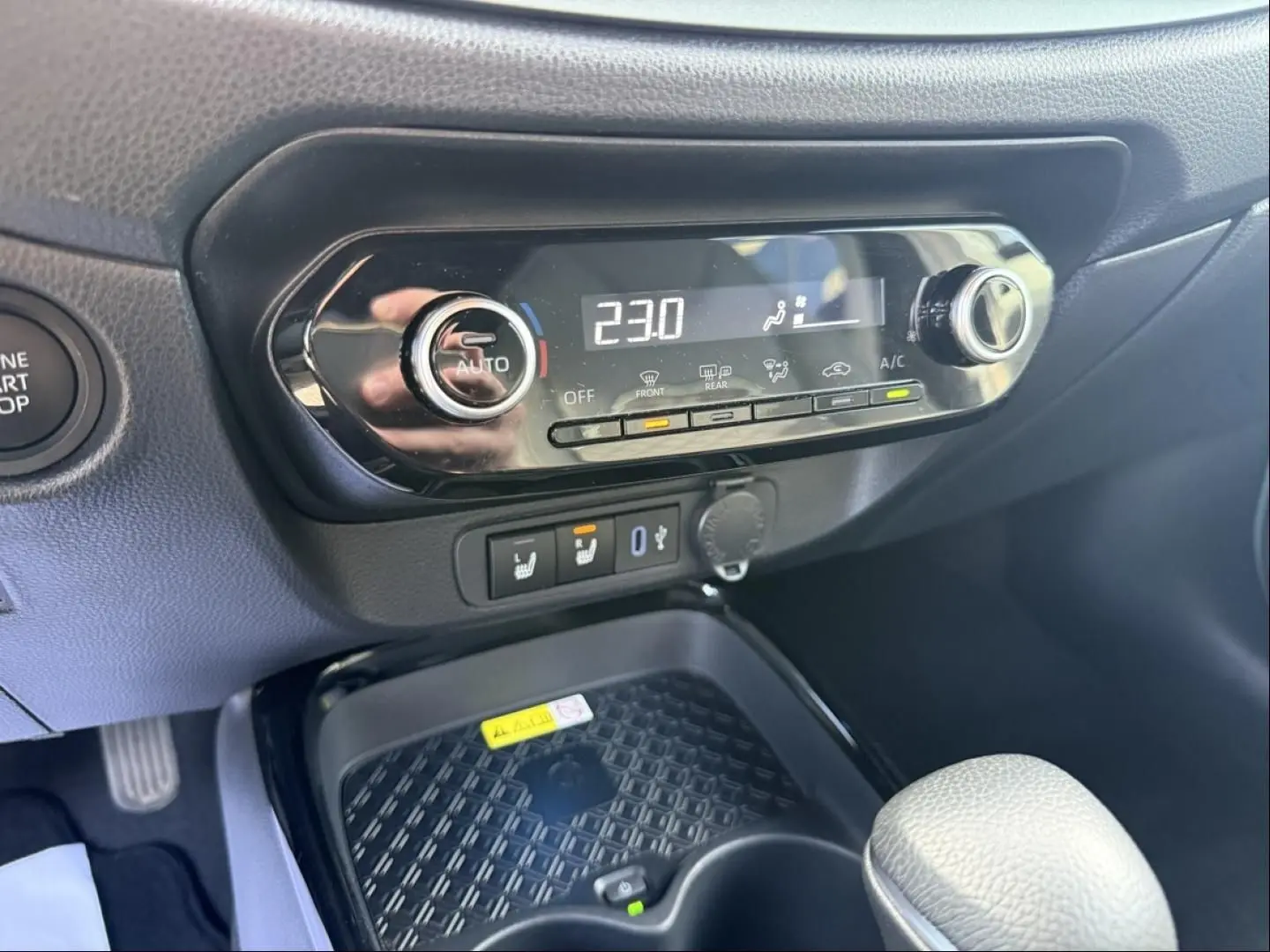 Gros plan sur la console centrale de la Toyota Aygo X 2025, montrant la commande de climatisation digitale et les boutons chauffants.