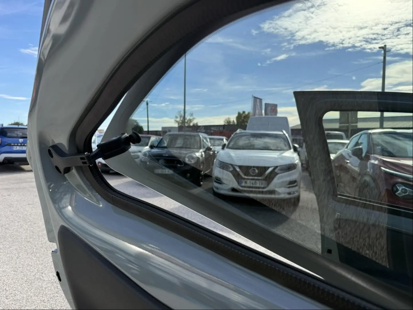 Vue partielle intérieure sur la portière arrière droite du Toyota Aygo X 2025 vert aventurine avec toit noir, montrant la vitre ouverte.