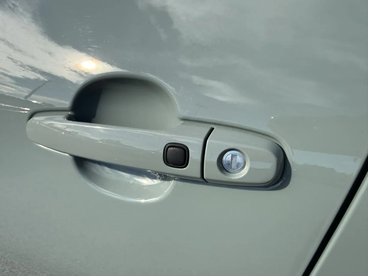 Poignée de porte avant droite de la Toyota Aygo X 2025 en vert aventurine avec bouton noir et serrure intégrée.