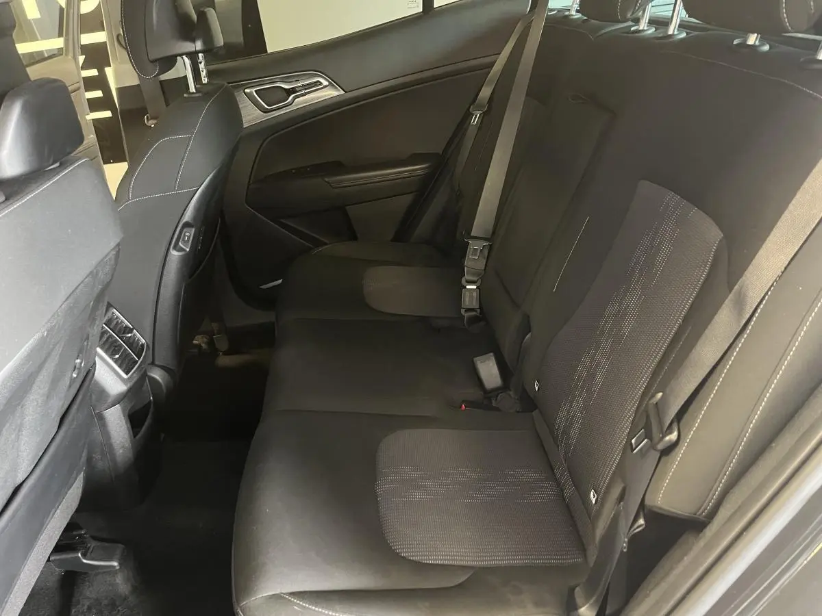 Vue latérale droite de la banquette arrière noire en tissu du Kia Sportage 2022 avec accoudoir central relevé.