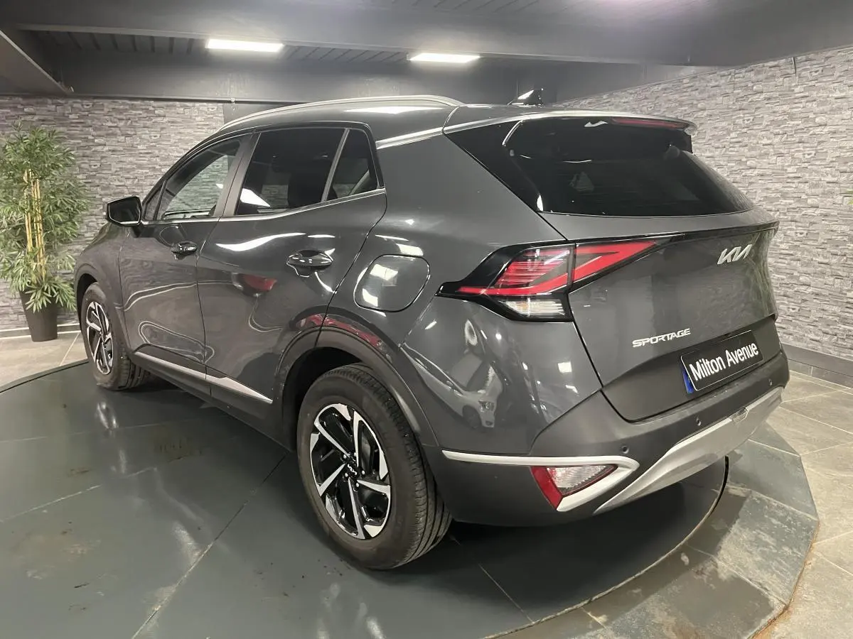 Vue 3/4 arrière droite du KIA Sportage gris métallisé avec jantes alliage et feux arrière LED distinctifs.