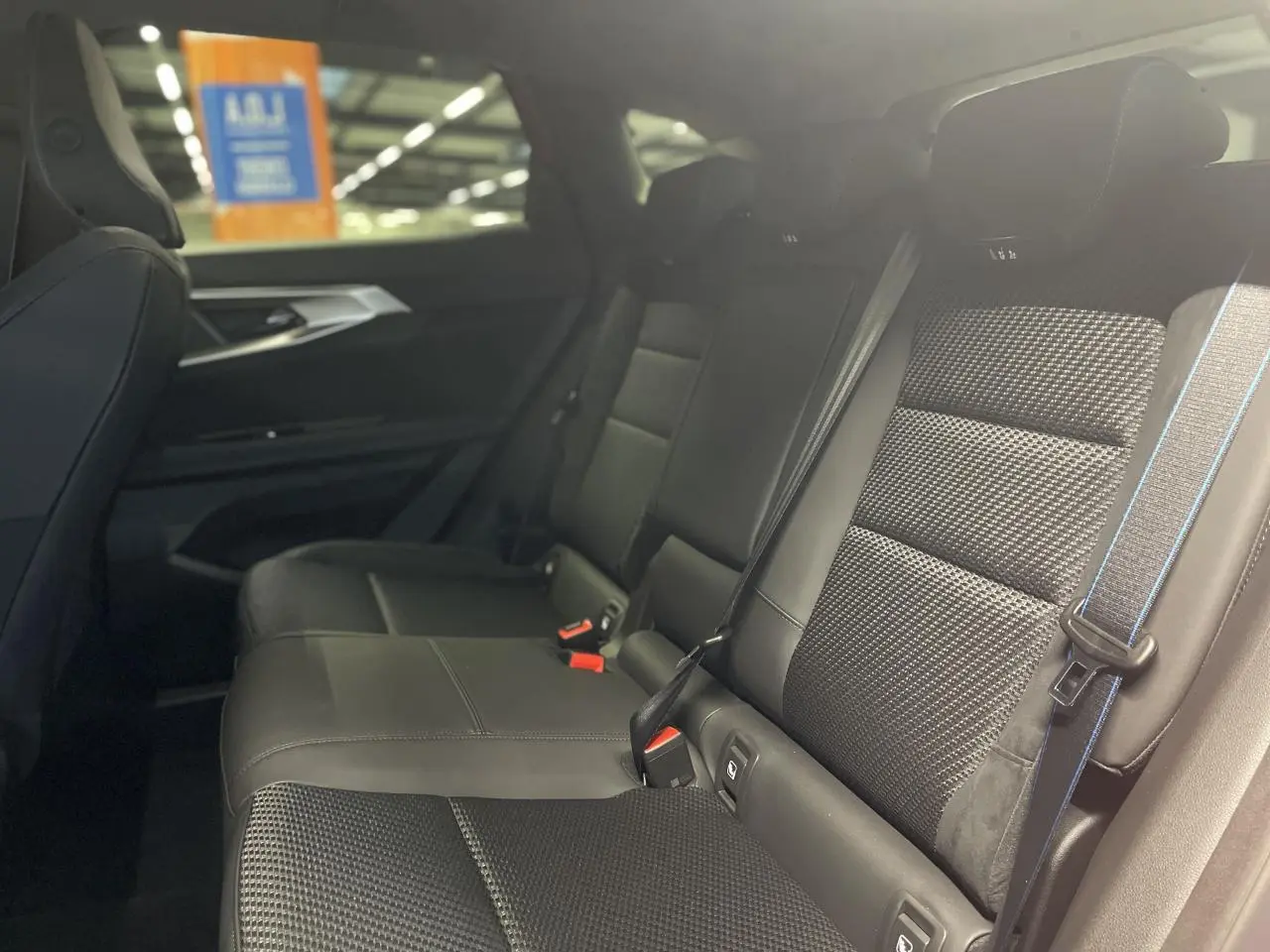 Vue latérale droite des sièges arrière en tissu carbone et Alcantara avec surpiqûres bleu blanc rouge du Renault Austral Esprit Alpine.