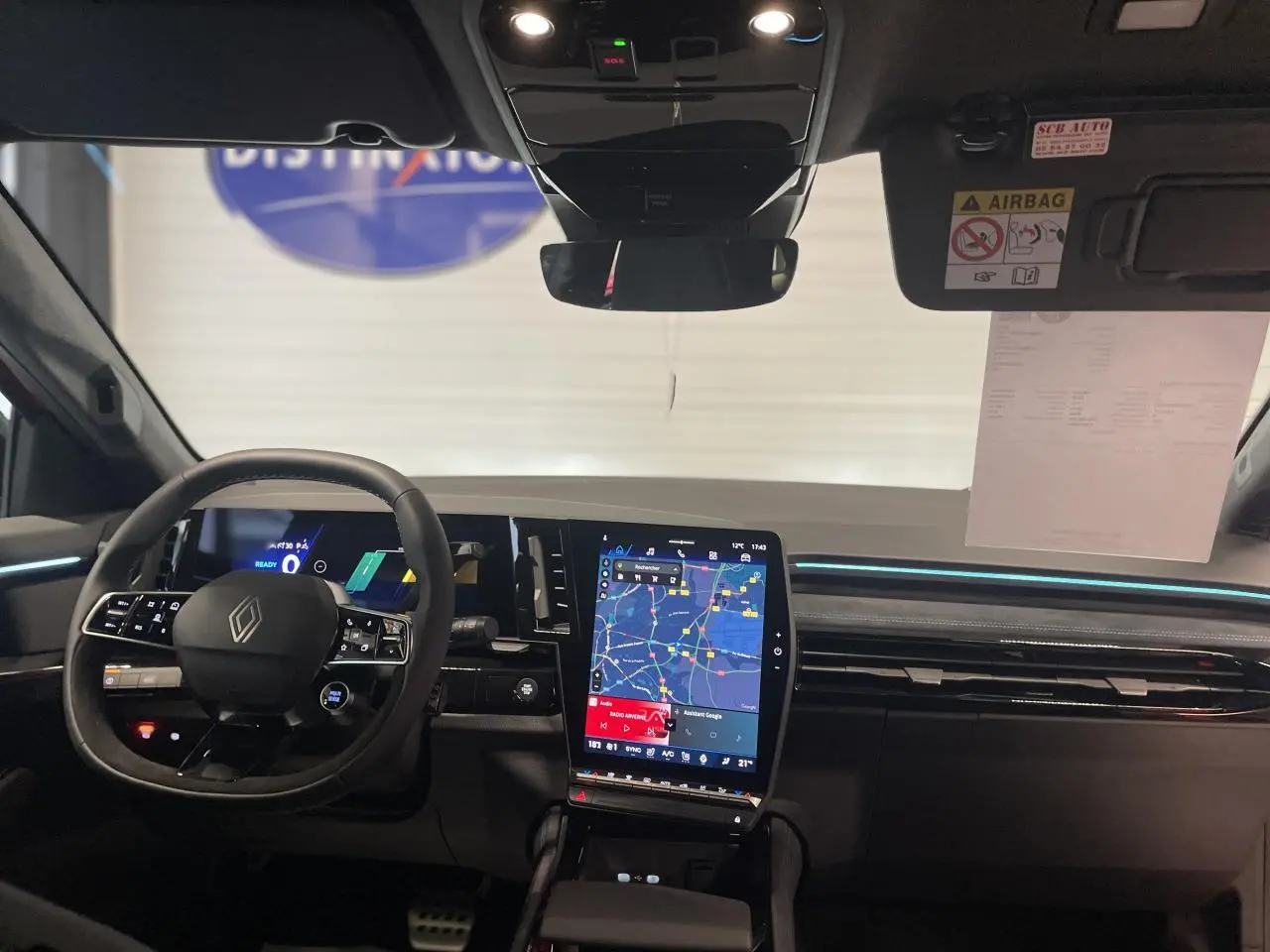 Vue intérieure avant du Renault Austral 2025 montrant le volant Alcantara et l'écran tactile vertical du système multimédia.