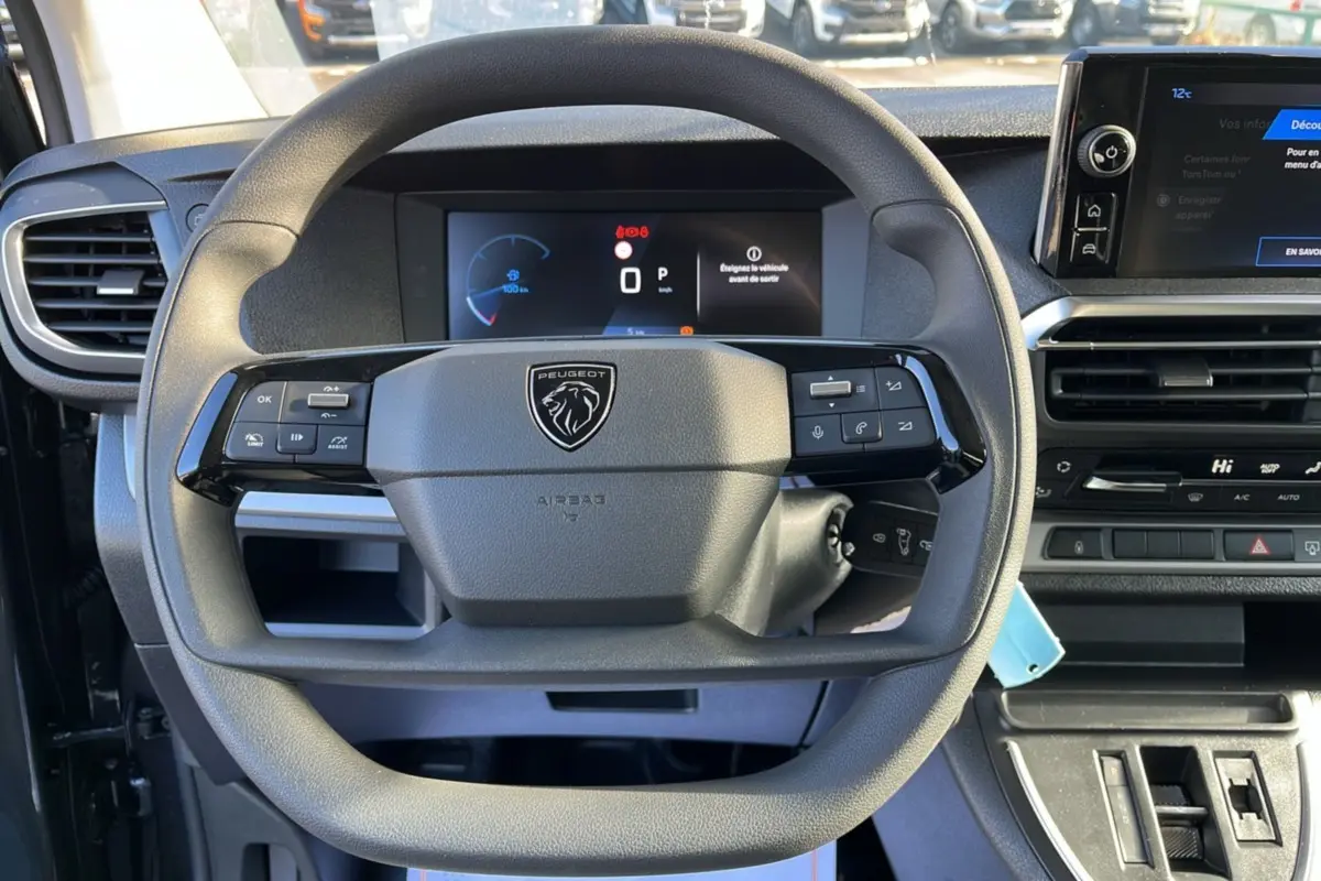 Vue rapprochée du volant multifonctions Peugeot Traveller 2025 avec tableau de bord numérique et écran tactile.