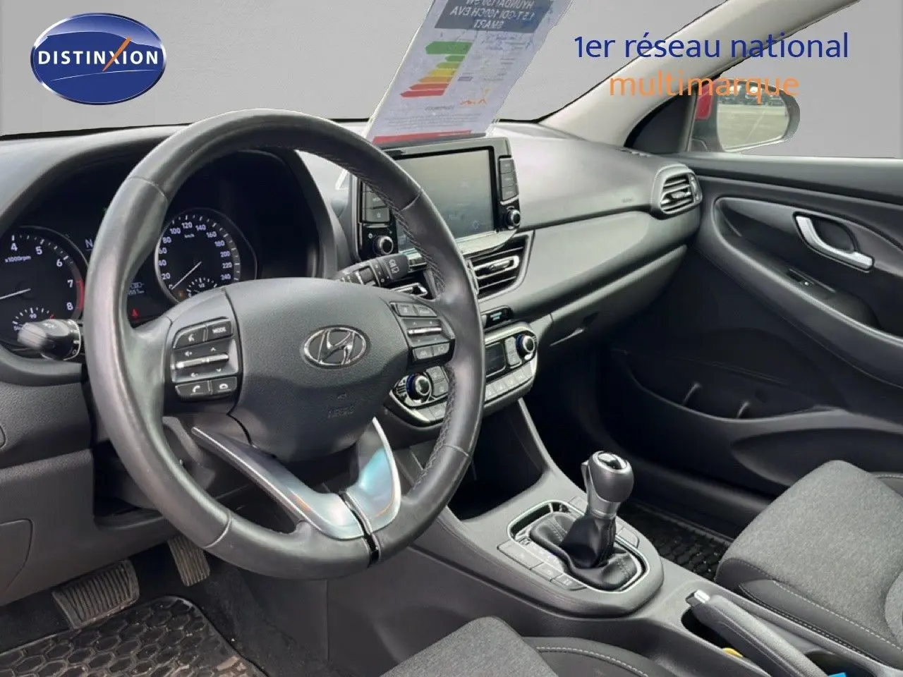 Vue intérieure côté conducteur du tableau de bord et volant en cuir noir de la Hyundai i30 SW 2023.