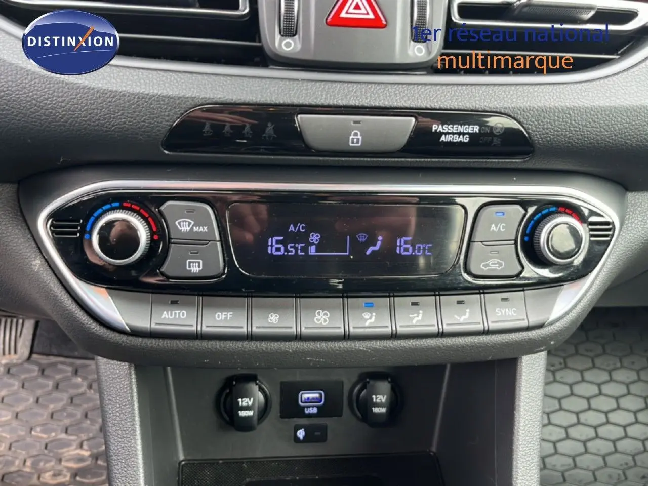 Vue rapprochée du tableau de bord de la Hyundai i30 SW 2023, montrant la console de climatisation digitale et les ports USB et 12V.