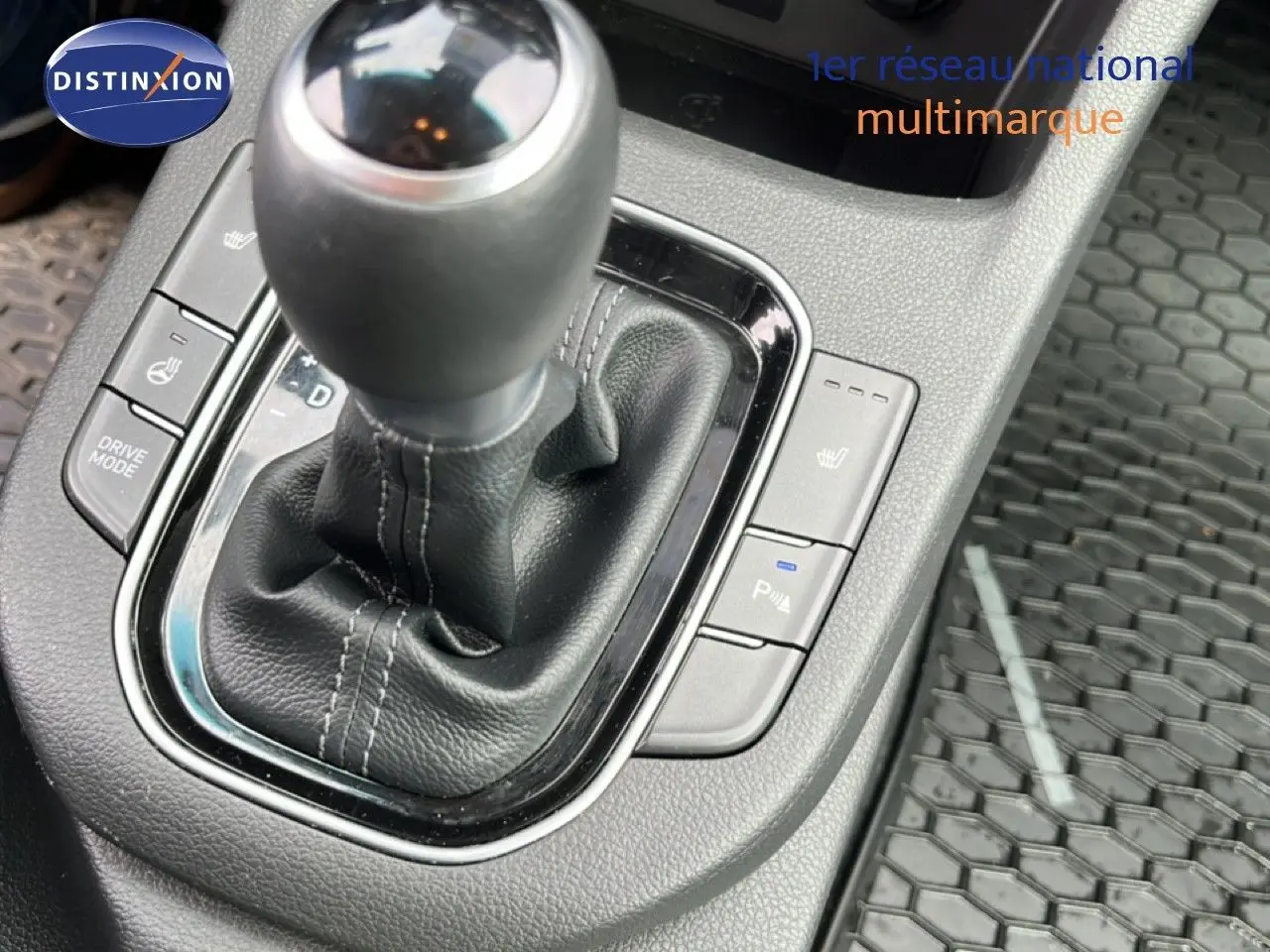 Gros plan sur le levier de vitesses automatique en cuir noir de la Hyundai i30 SW 2023, avec commandes chauffantes visibles.