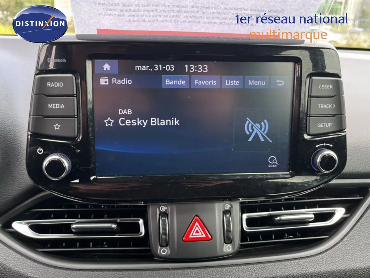 Vue rapprochée de l’écran multimédia central noir brillant de la Hyundai i30 SW 2023 avec commandes tactiles et boutons physiques.