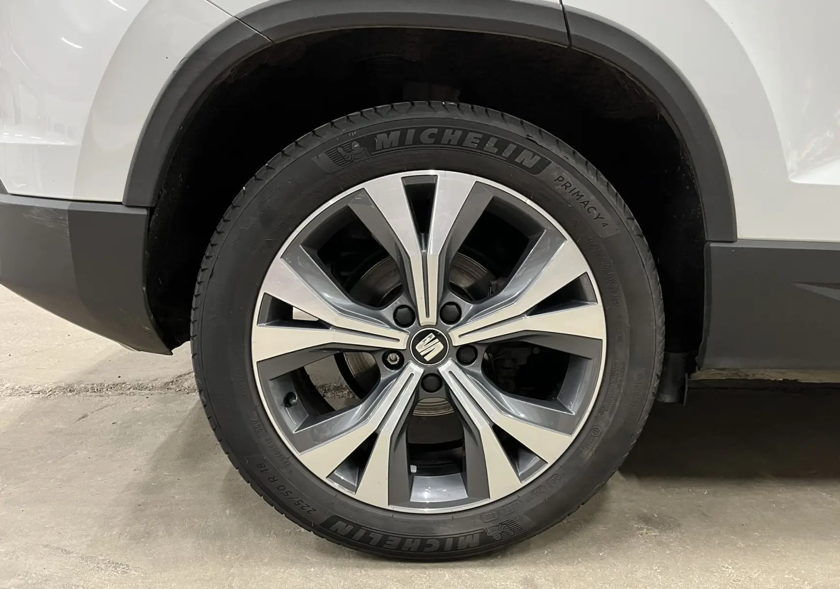 Gros plan sur la roue avant droite d'un SEAT Ateca blanc, mettant en valeur la jante alliage et le pneu Michelin.