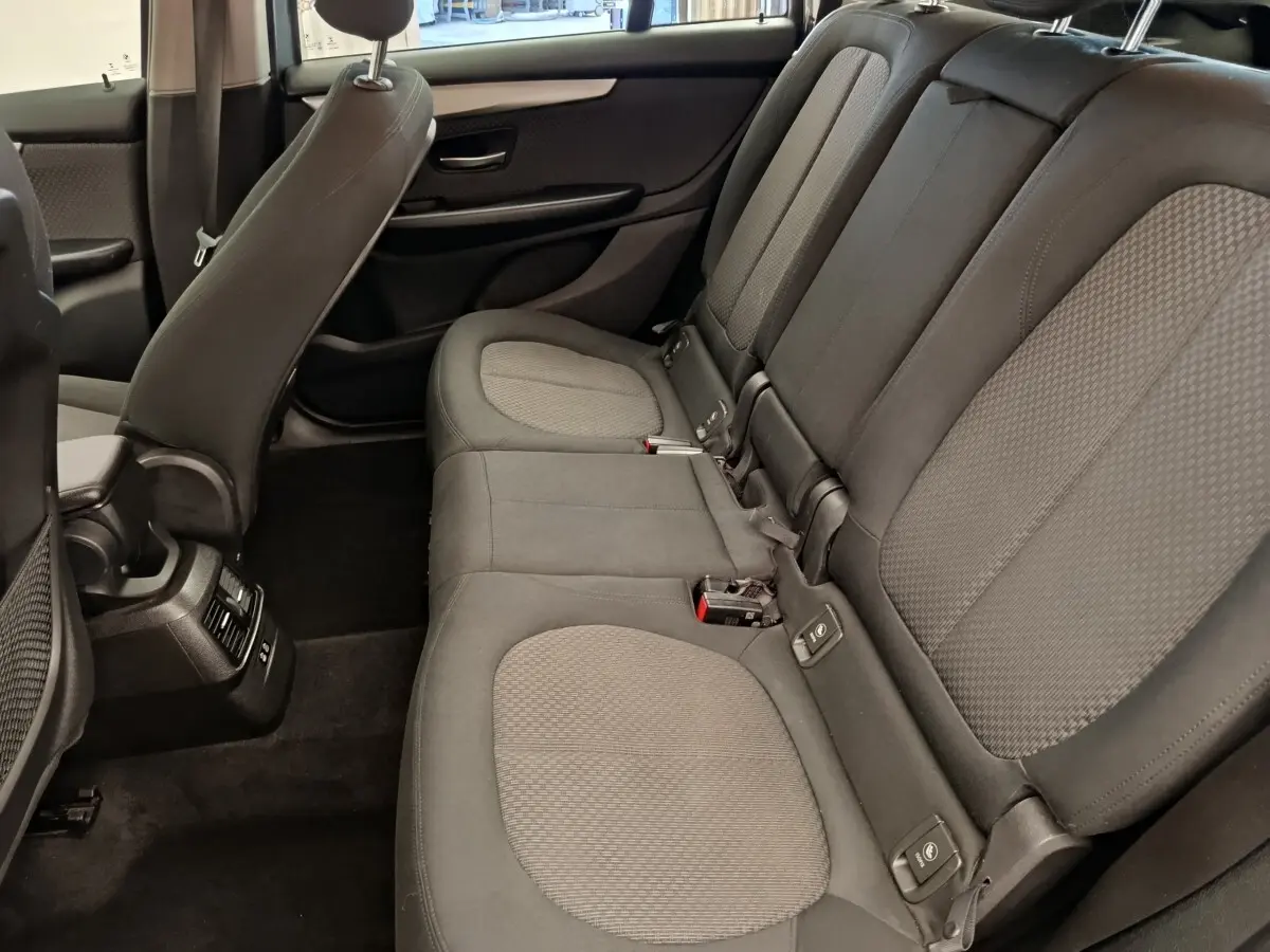 Vue intérieure côté droit des sièges arrière gris foncé avec appuie-têtes et ceintures de sécurité visibles dans une BMW Série 2 Gran Tourer.