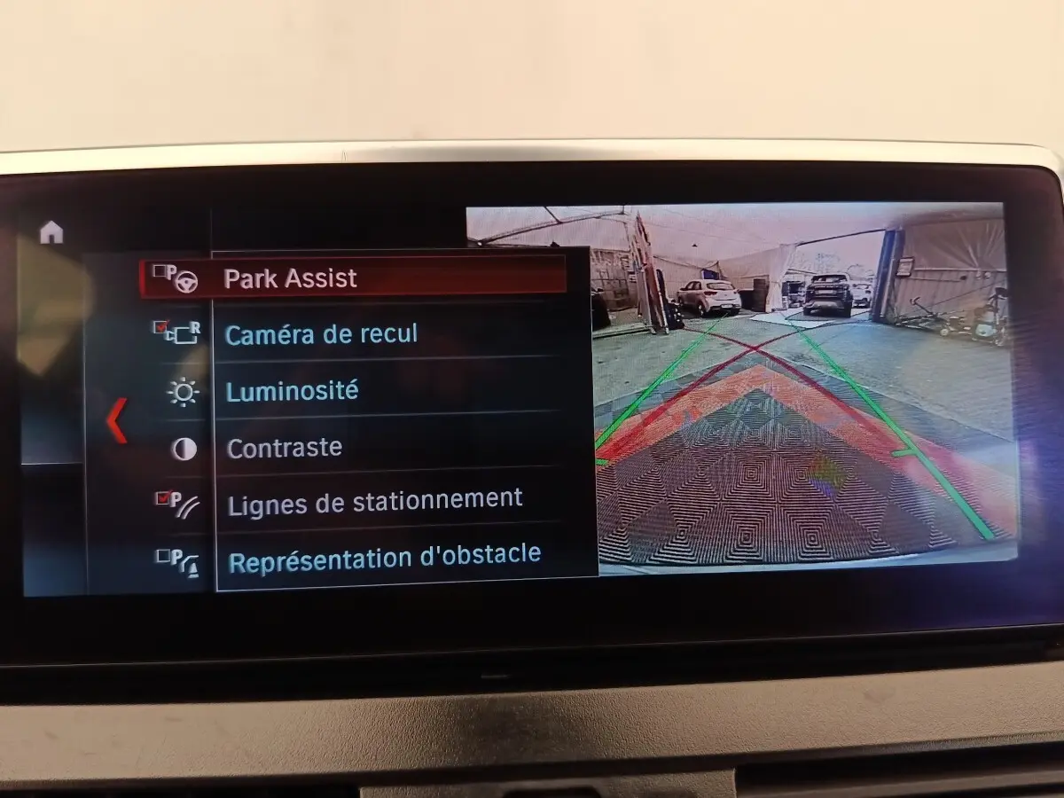 Écran multimédia de BMW Série 2 Gran Tourer 218i montrant la caméra de recul avec lignes de stationnement colorées.