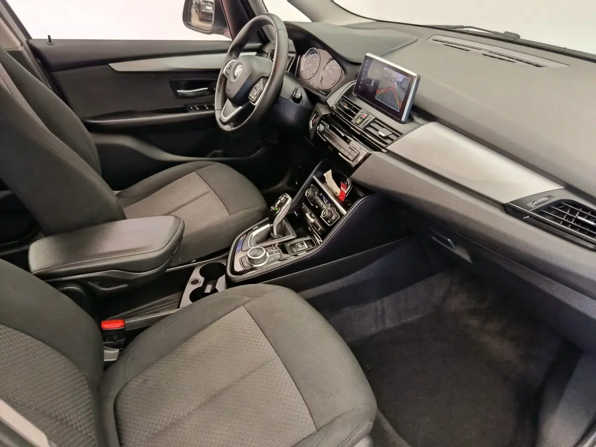 Vue intérieure côté conducteur de la BMW Série 2 Gran Tourer 218i Lounge 2022 avec sièges tissu gris et tableau de bord moderne.