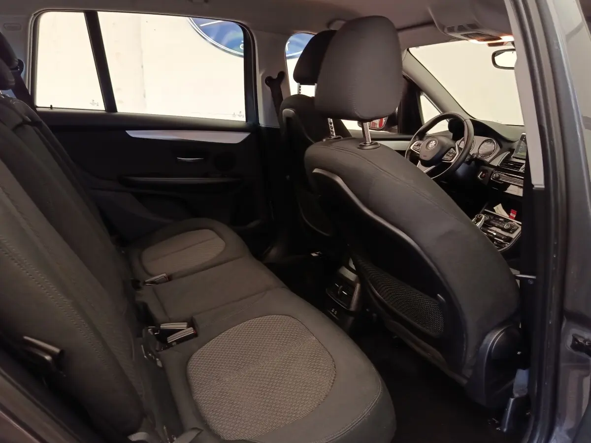 Vue intérieure côté gauche montrant les sièges arrière et le poste de conduite d'une BMW Série 2 Gran Tourer gris clair.