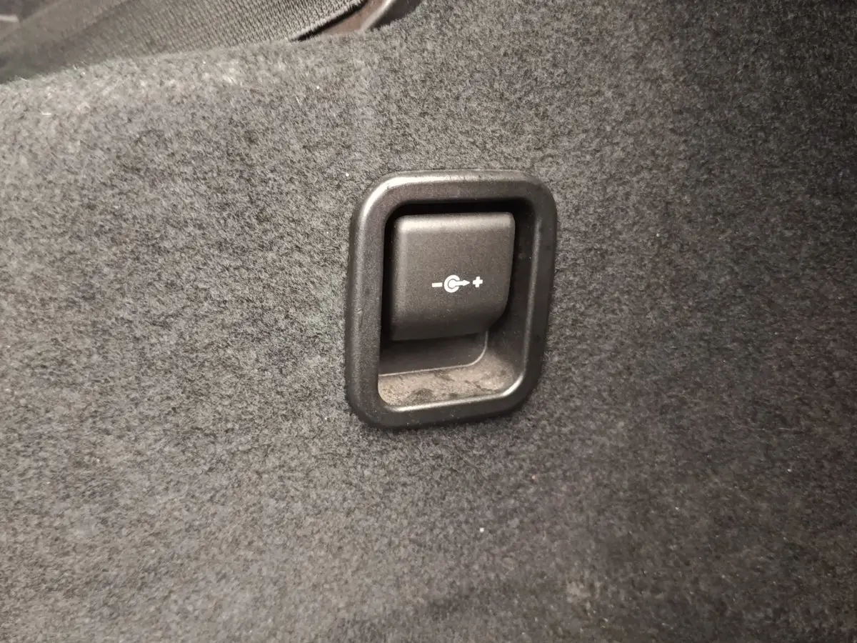 Gros plan sur le bouton de réglage de la récupération d'énergie dans le coffre gris foncé d'une BMW Série 2 Gran Tourer F46.
