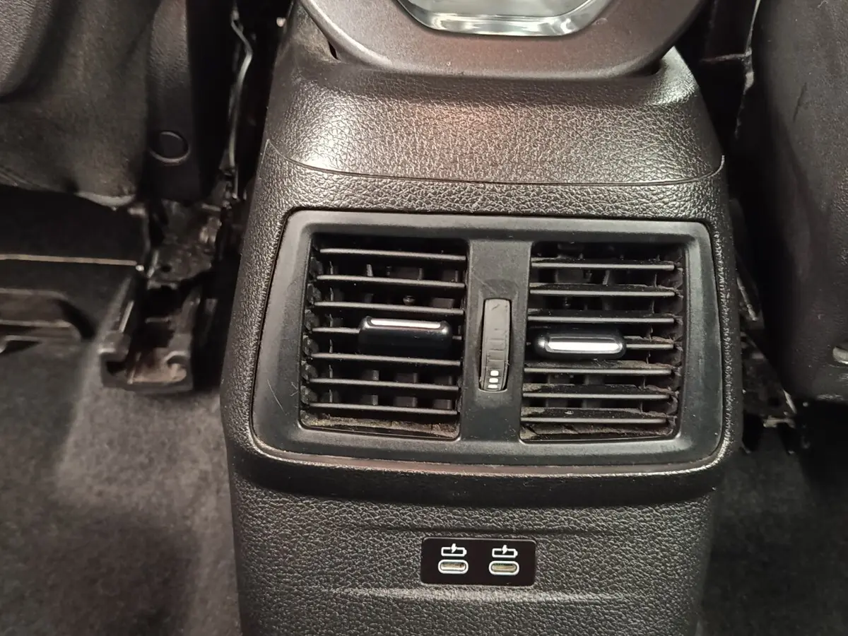 Vue rapprochée des aérateurs arrière et ports USB-C noirs dans l’habitacle d’une BMW Série 2 Gran Tourer gris clair.