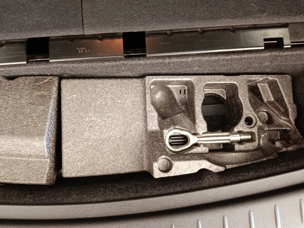 Coffre ouvert montrant le rangement en mousse avec outil de remorquage dans une BMW Série 2 Gran Tourer gris clair.