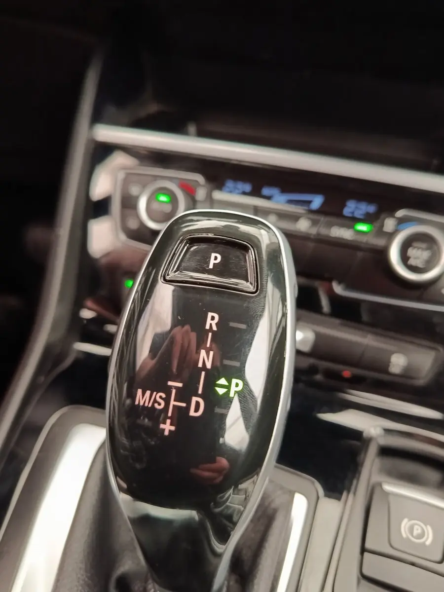 Gros plan sur le levier de vitesses automatique noir brillant de la BMW Série 2 Gran Tourer 218i Lounge 2022, intérieur moderne.