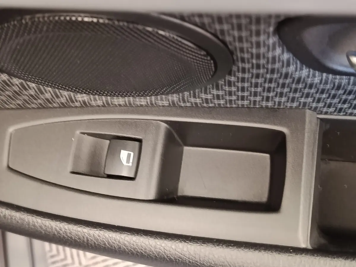 Gros plan sur le bouton de commande électrique de la vitre côté conducteur dans une BMW Série 2 Gran Tourer F46 218i Lounge gris clair.