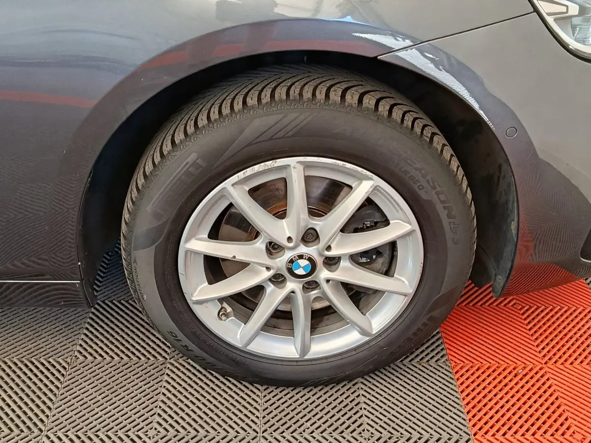 Gros plan sur la roue avant droite gris clair d'une BMW Série 2 Gran Tourer F46 avec jante alu multi-branches.