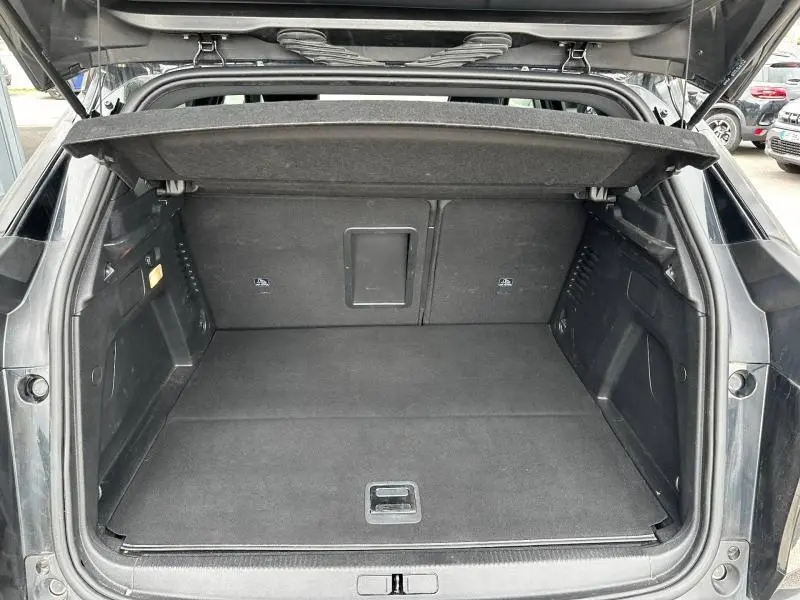 Coffre ouvert vu de l'arrière d'un Peugeot 3008 noir Perla Nera, montrant un espace de chargement propre et spacieux.