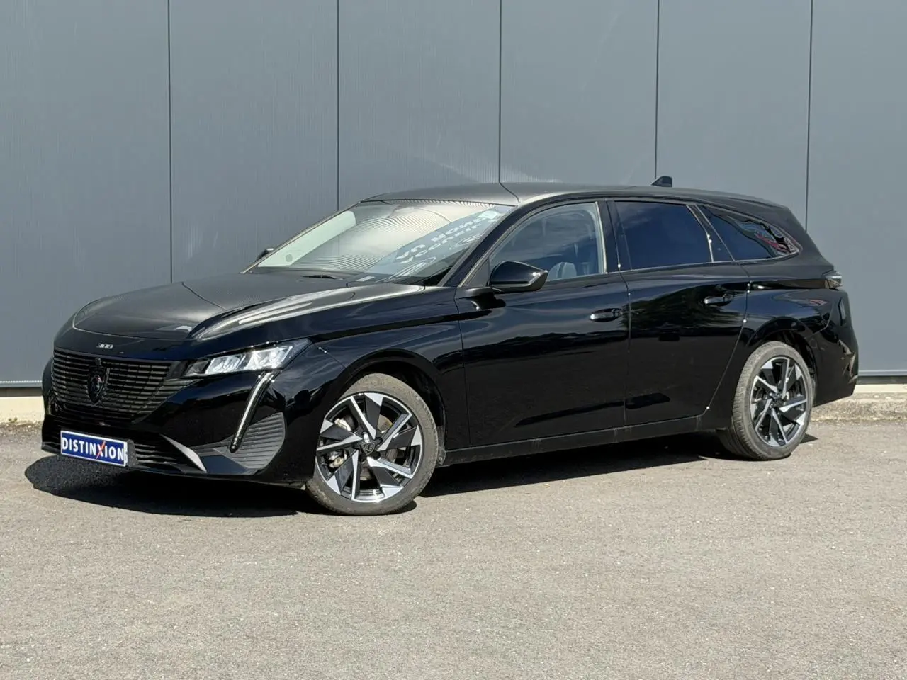 Peugeot 308 SW noir Perla vue 3/4 avant droit, jantes alliage 17'' et vitres surteintées visibles.