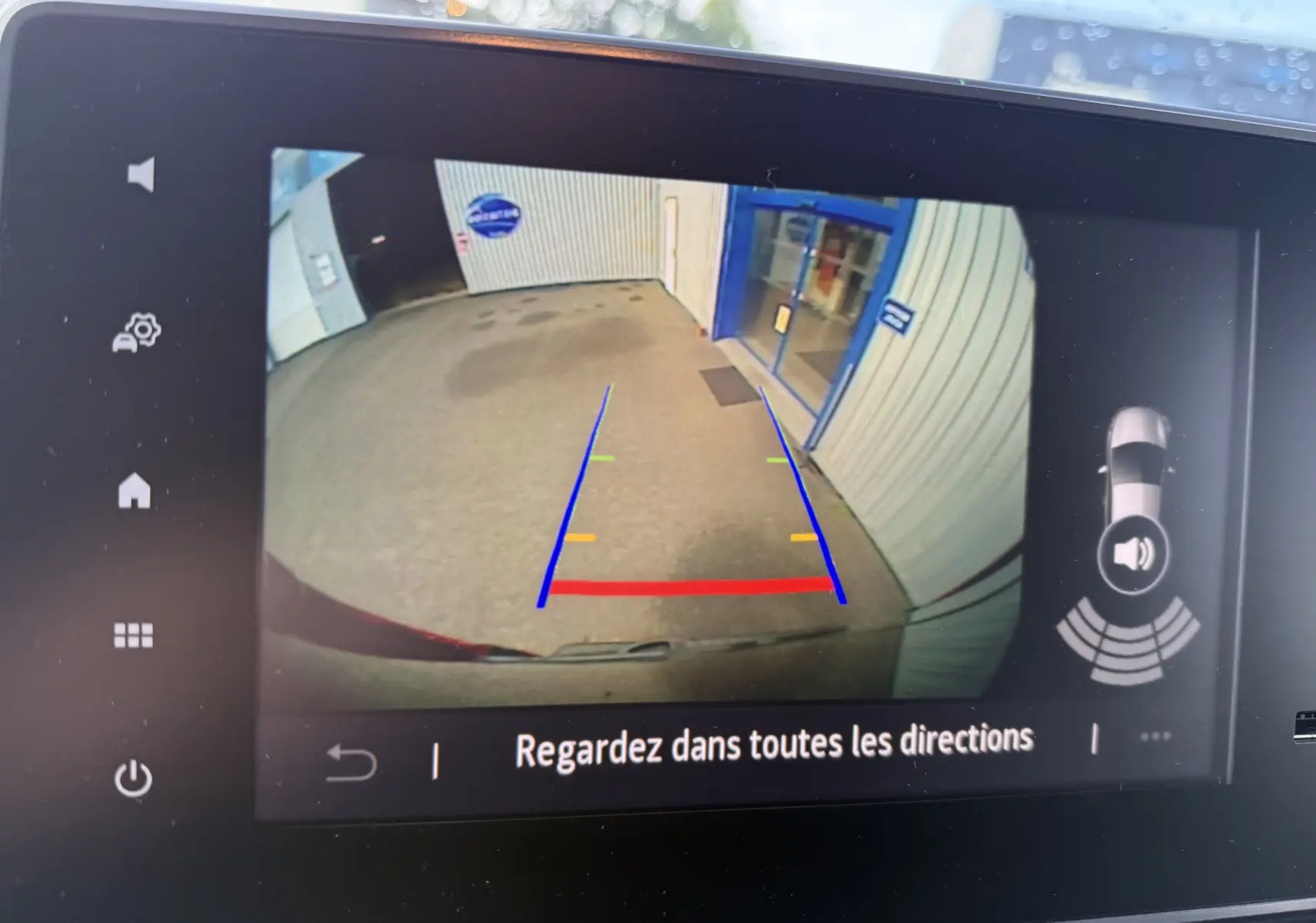 Vue de la caméra de recul du Renault Trafic Fourgon noir crépuscule, montrant l'arrière et les lignes de guidage colorées.