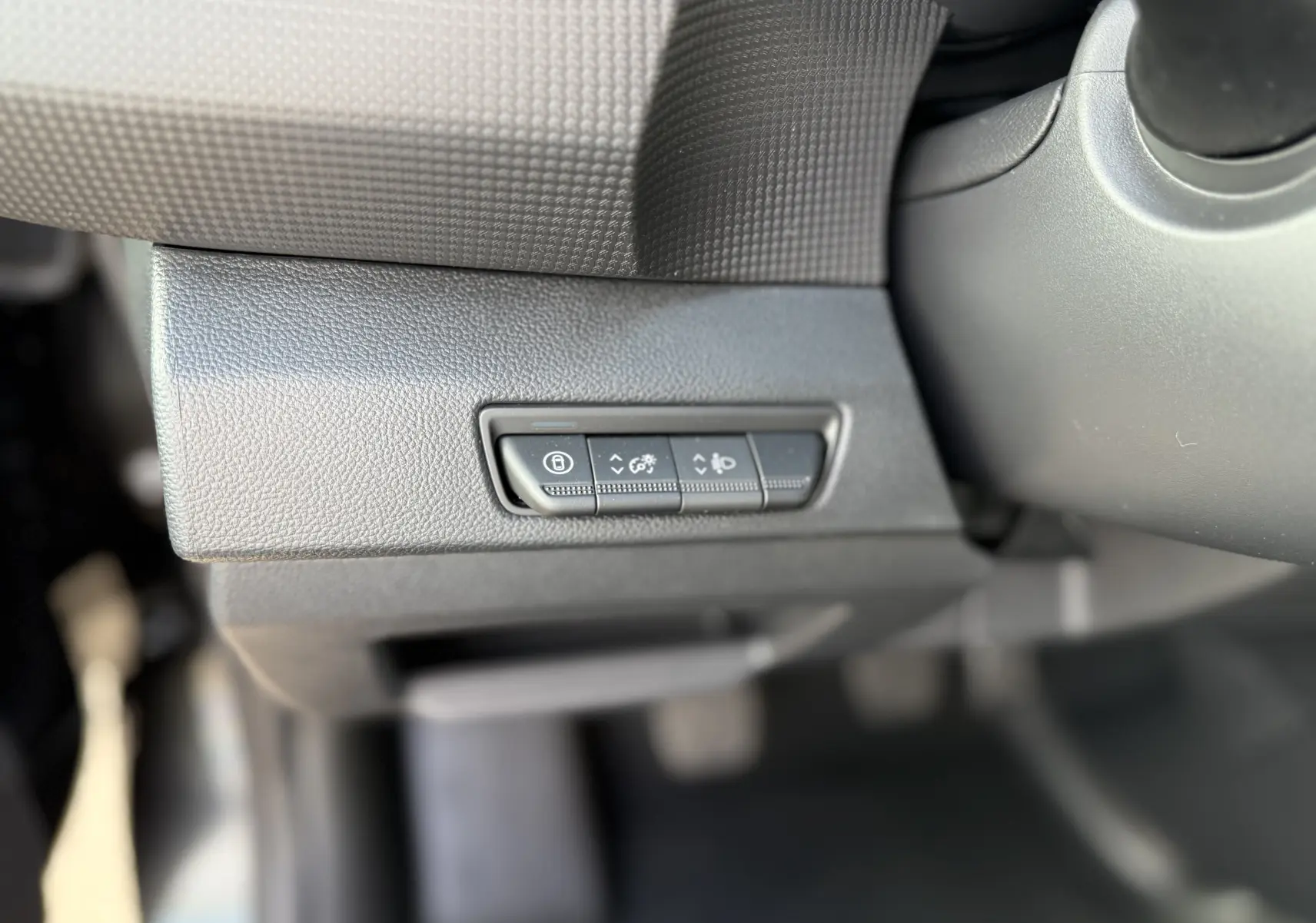 Gros plan sur les boutons de réglage du tableau de bord noir du Renault Trafic Fourgon 2025, côté gauche du conducteur.