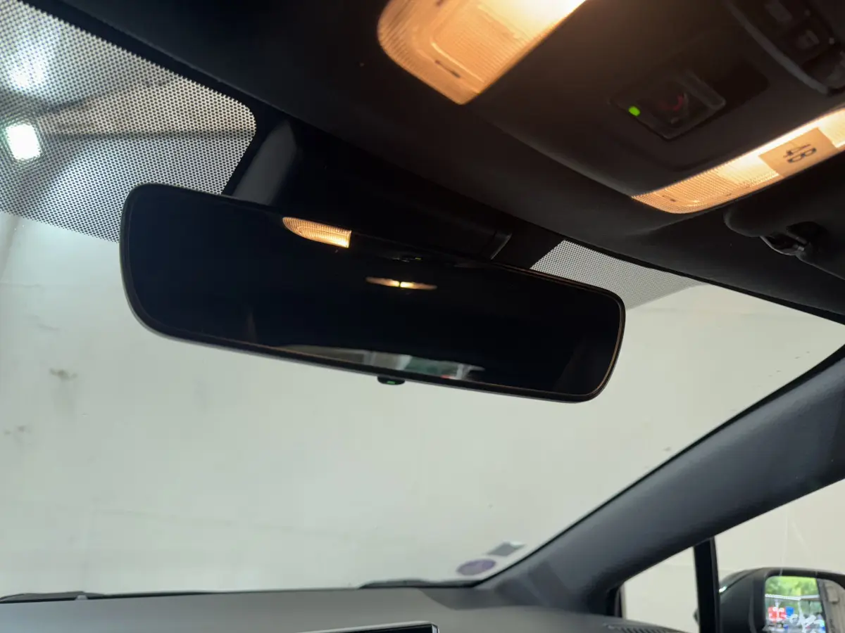 Rétroviseur intérieur et plafonnier éclairé dans l’habitacle sombre d’une Toyota Corolla Hybride 122h Collection 2021.