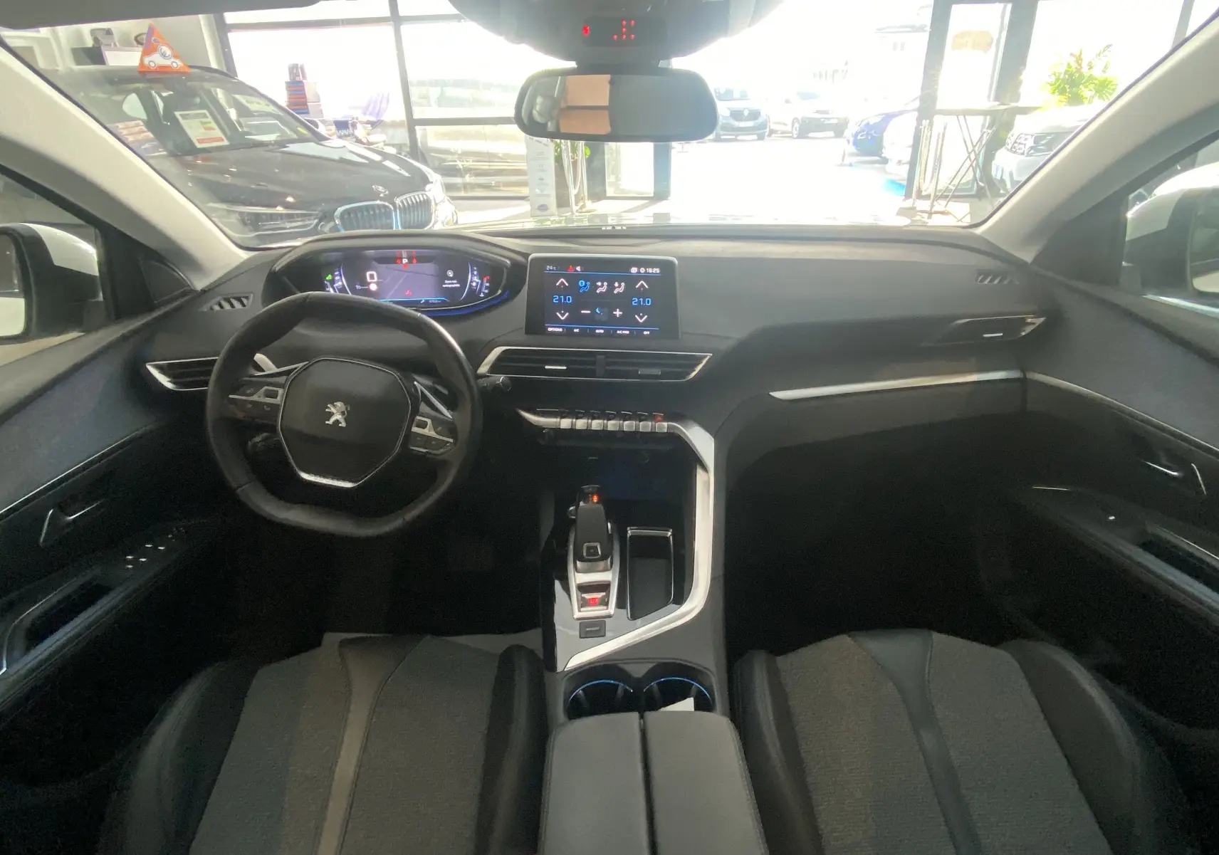 Intérieur du Peugeot 5008 blanc, vue frontale du poste de conduite avec tableau de bord numérique et écran tactile central.