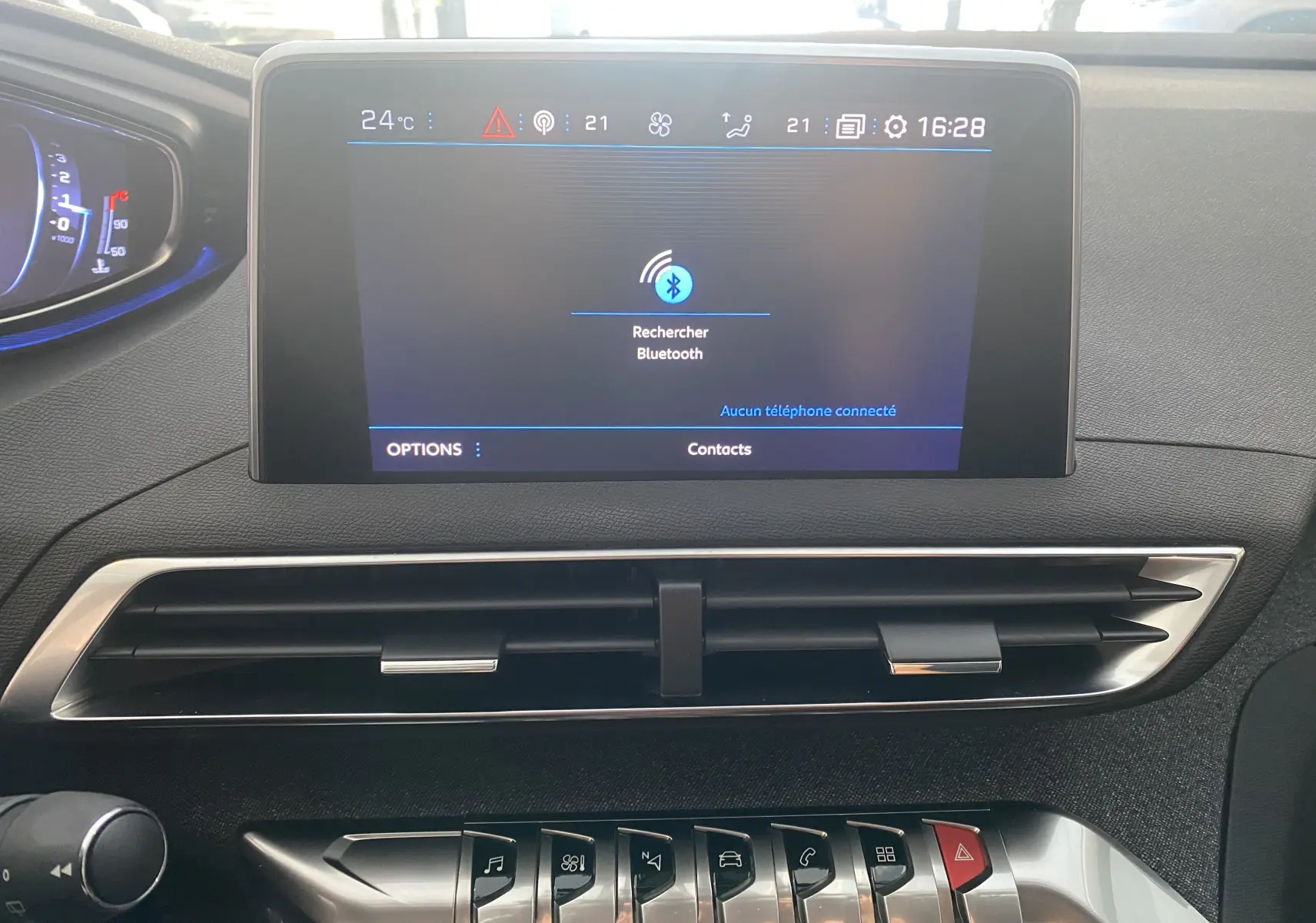 Écran tactile central du tableau de bord du Peugeot 5008 blanc, affichant la recherche Bluetooth et les commandes climatisation.