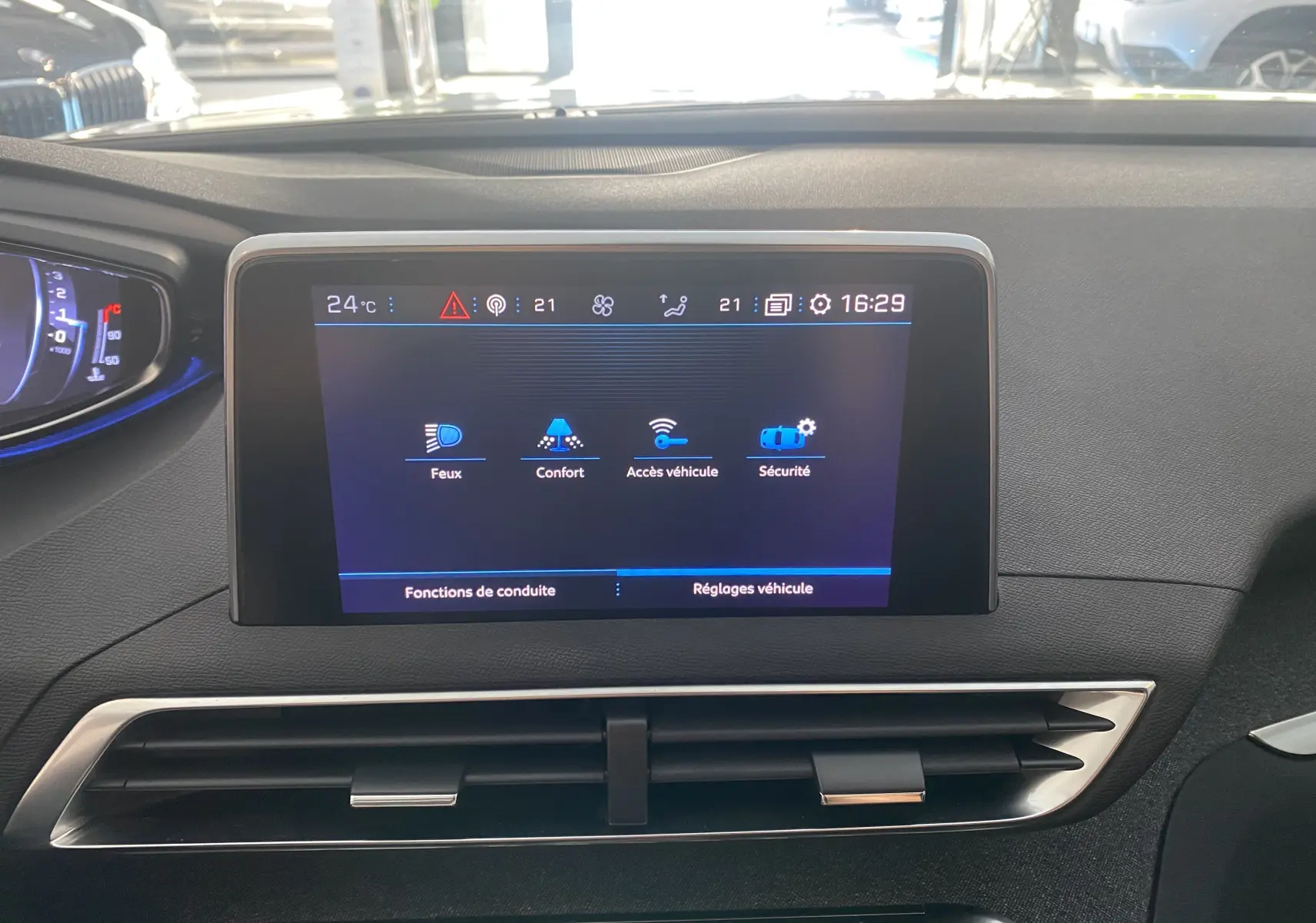 Écran tactile central du tableau de bord du Peugeot 5008 blanc, affichant les réglages de conduite et sécurité.