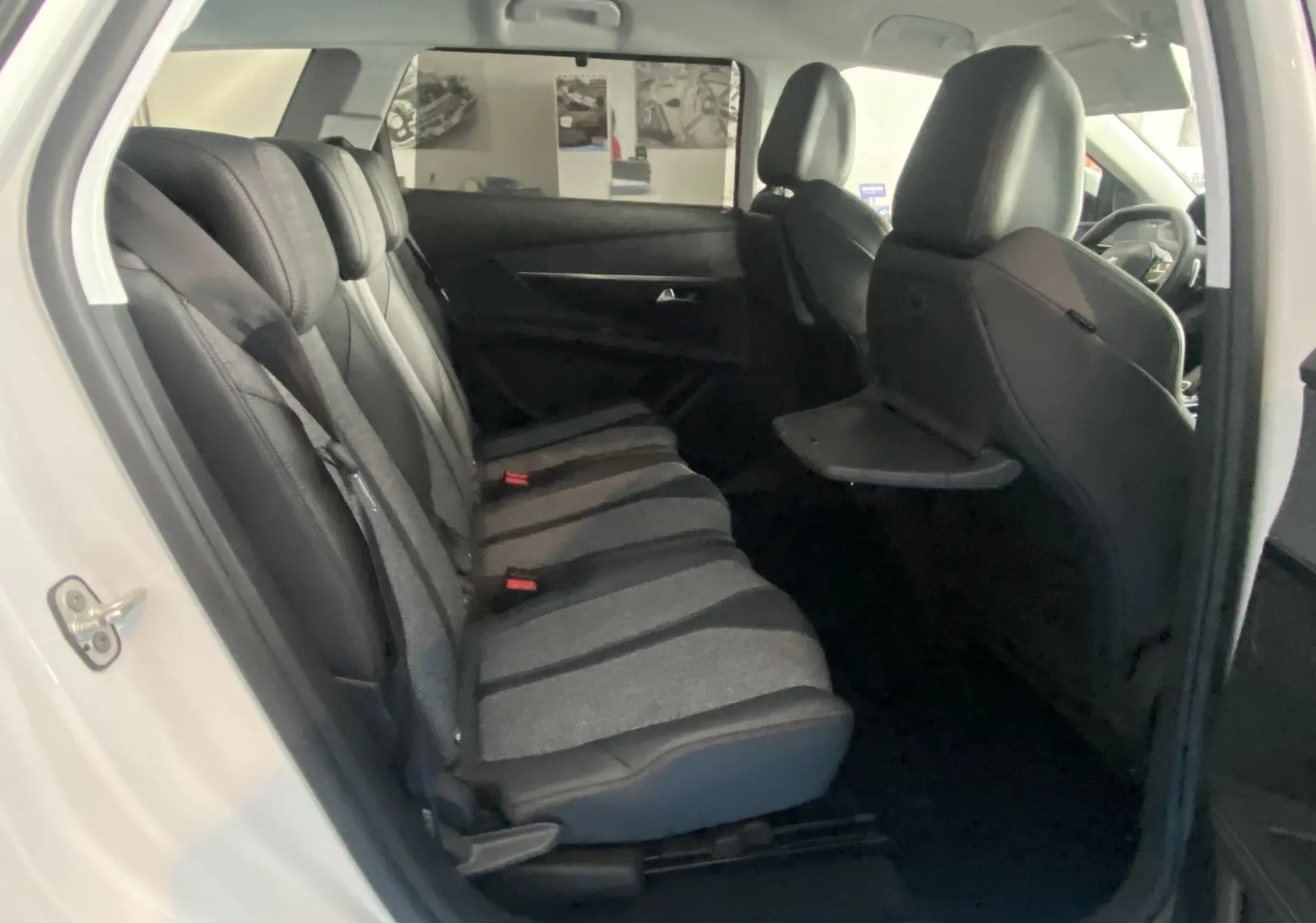 Vue intérieure côté gauche montrant les sièges arrière en tissu gris et cuir noir du Peugeot 5008 blanc.