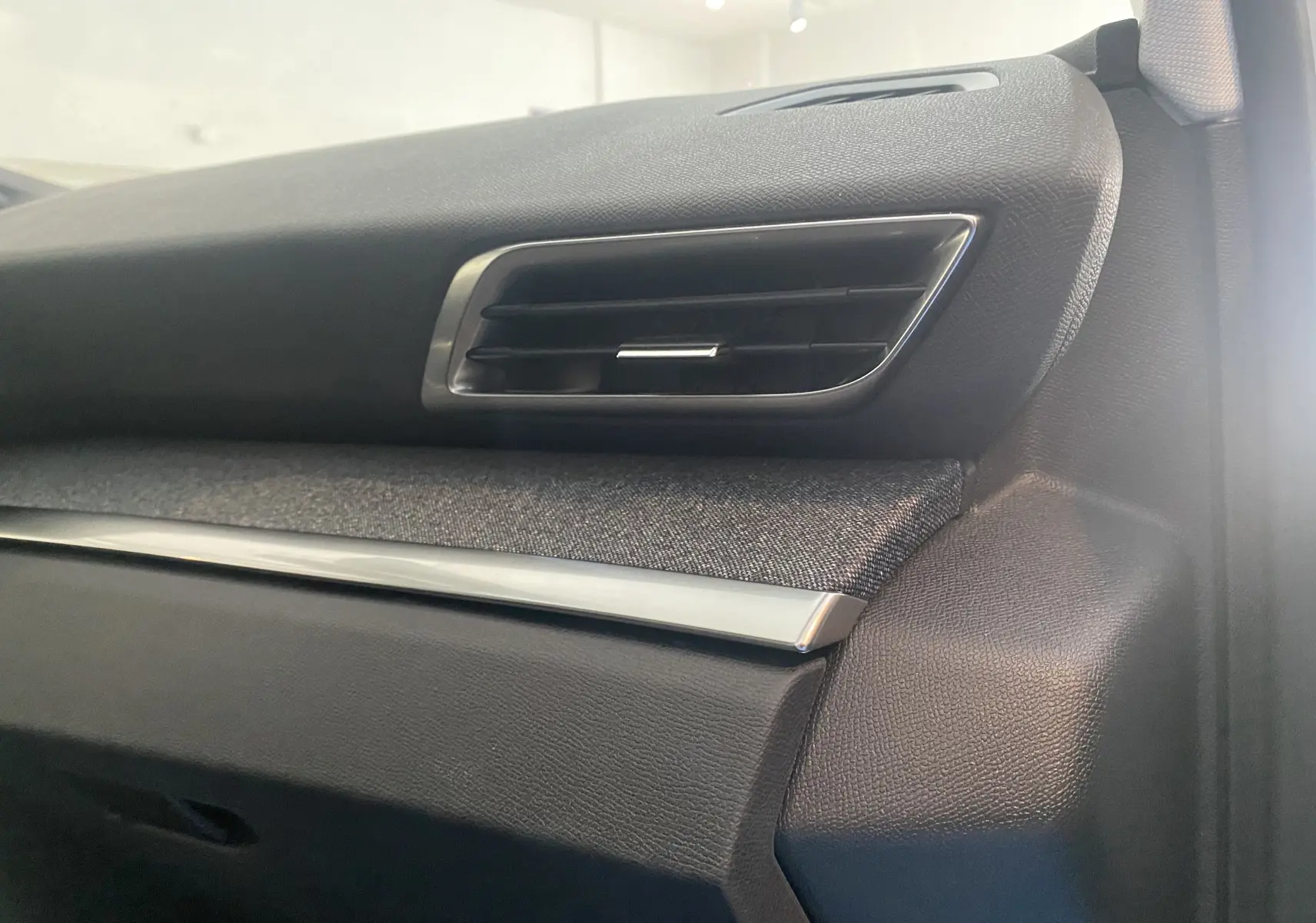 Détail de la grille d'aération côté passager du tableau de bord du Peugeot 5008 blanc, finition intérieure gris noir.