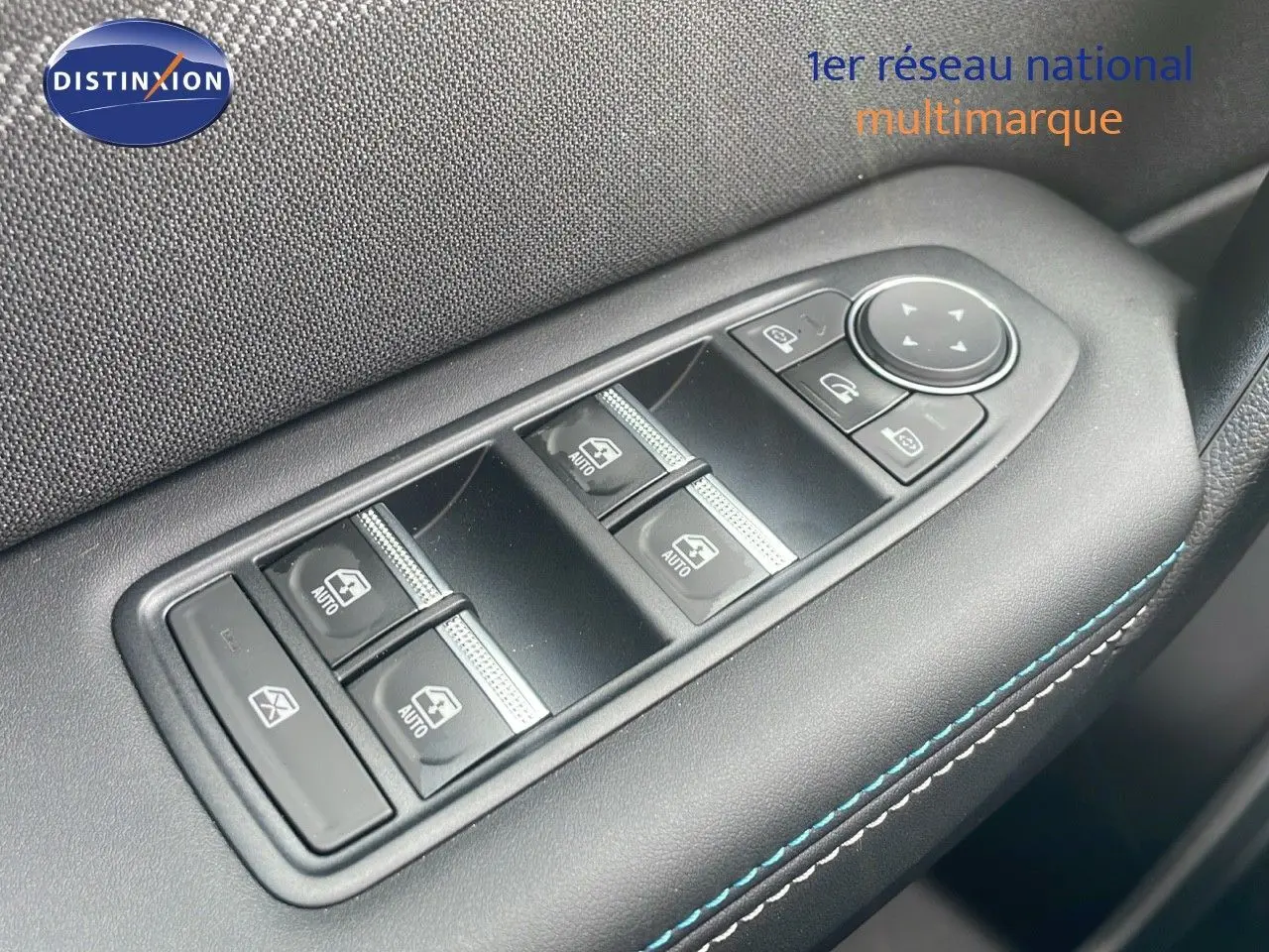 Gros plan sur les commandes des vitres électriques et rétroviseurs du côté conducteur du Renault Captur gris cassiopée toit noir.