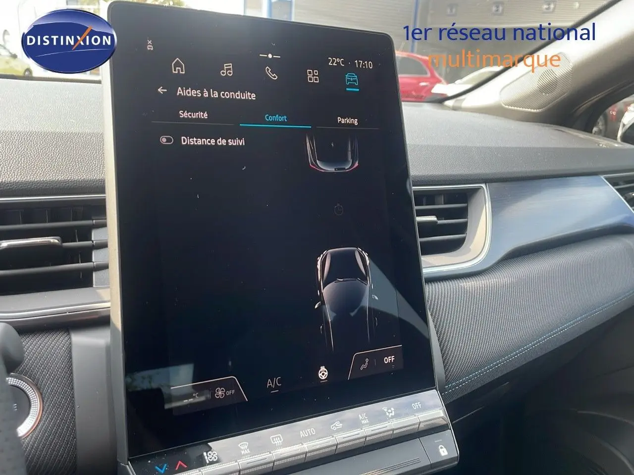 Vue rapprochée de l'écran tactile central du tableau de bord du Renault Captur gris cassiopée avec toit noir, affichant les aides à la conduite.