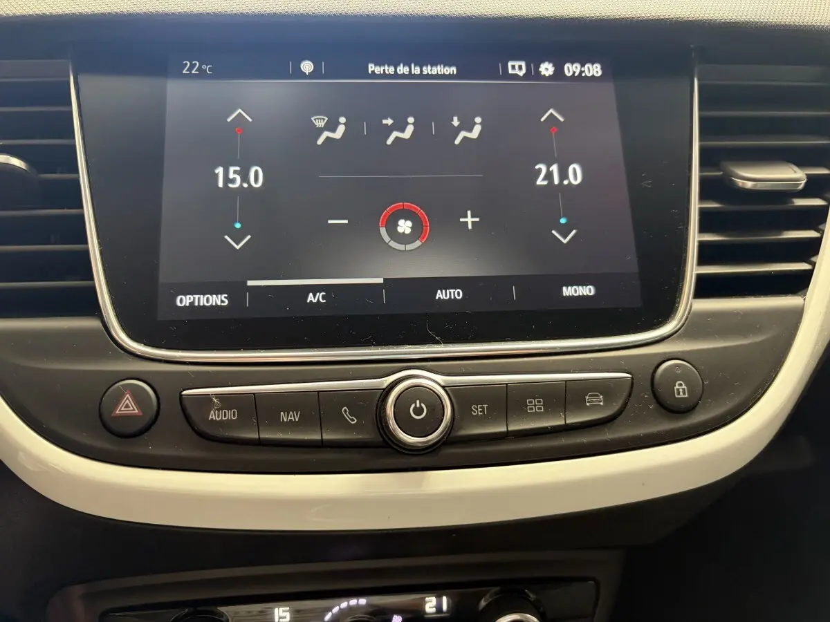 Tableau de bord de l’Opel Crossland blanc, vue rapprochée de l’écran tactile central et des commandes de climatisation.