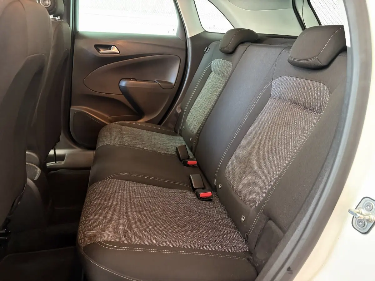 Vue côté droit de la banquette arrière grise et noire de l’Opel Crossland blanc, avec appuie-têtes et ceintures visibles.