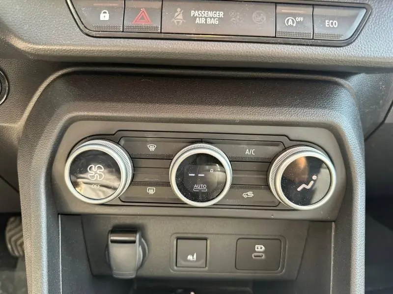 Vue rapprochée des commandes de climatisation et des boutons de fonction du tableau de bord d'une Dacia Sandero 2025.