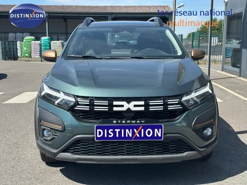 Vue de face d'une Dacia Sandero Stepway 2025 en Vert Cèdre métallisé avec calandre noire et logo central distinctif.