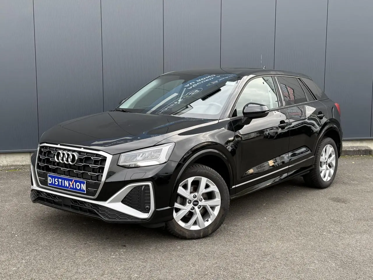 Audi Q2 35 TFSI S-Line noir Mythe en 3/4 avant droit, avec jantes alliage 17 pouces et calandre distinctive S-Line.