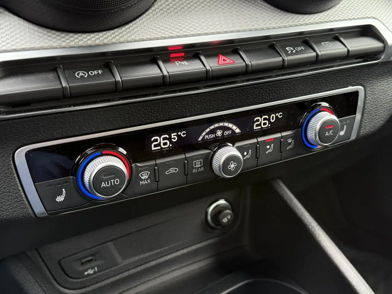 Gros plan sur la console centrale de l'Audi Q2 35 TFSI S-Line 2023, montrant la climatisation automatique à deux zones.