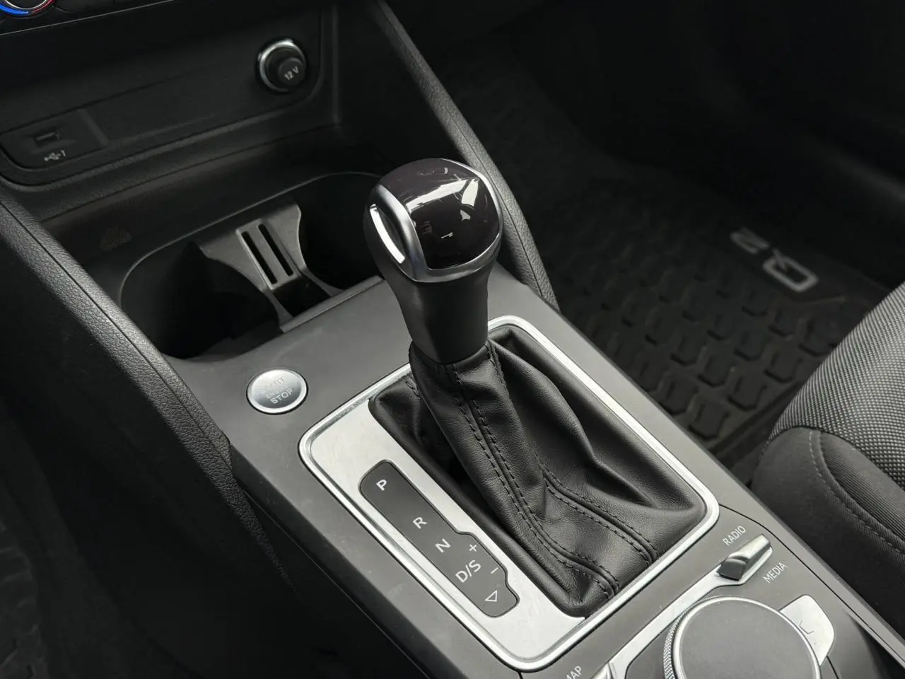 Gros plan sur le levier de vitesses automatique en cuir noir de l'Audi Q2 35 TFSI S-Line 2023.