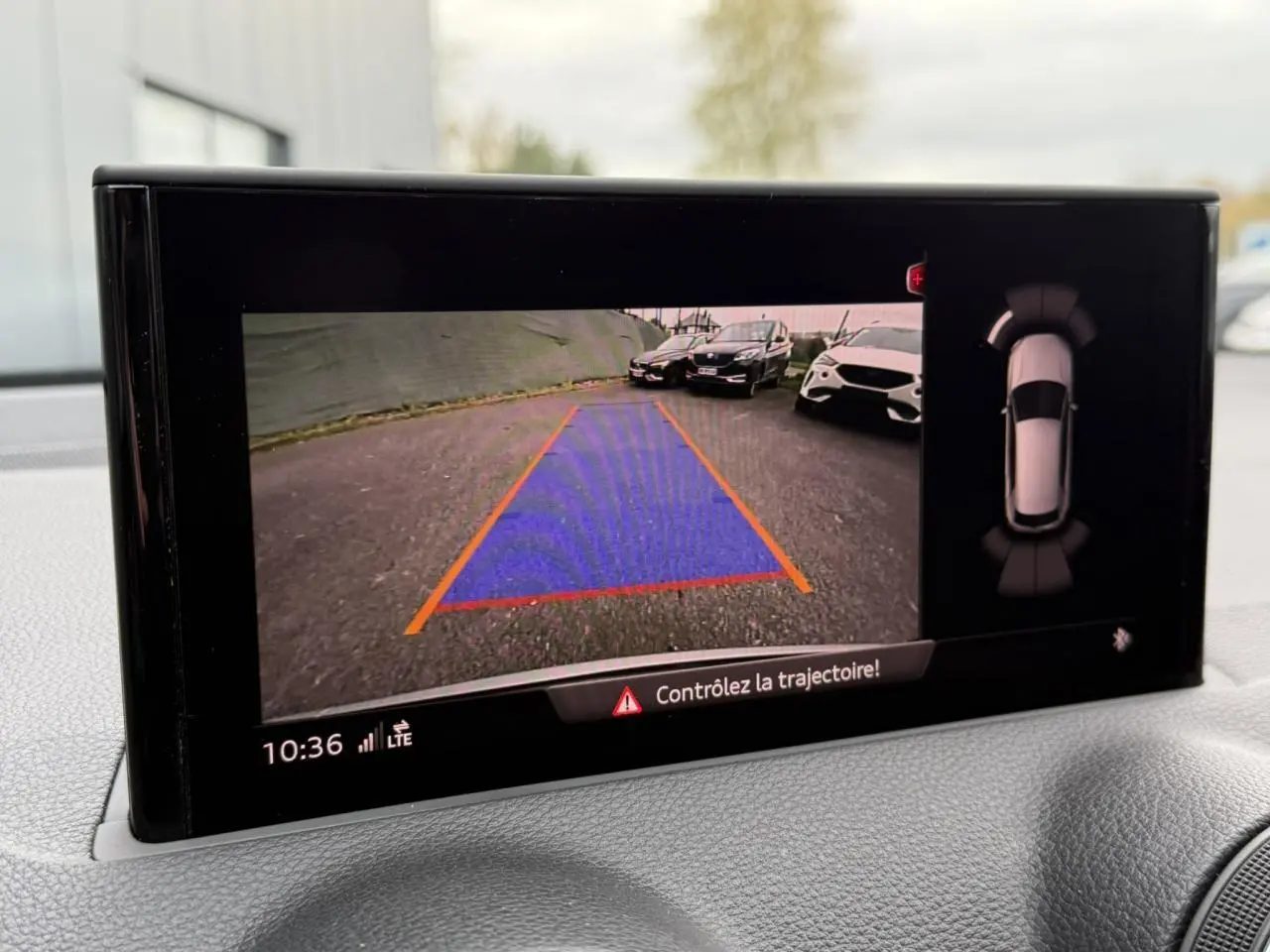 Affichage caméra de recul de l'Audi Q2 noir Mythe, avec guidage de trajectoire et vue 360° sur écran intérieur.