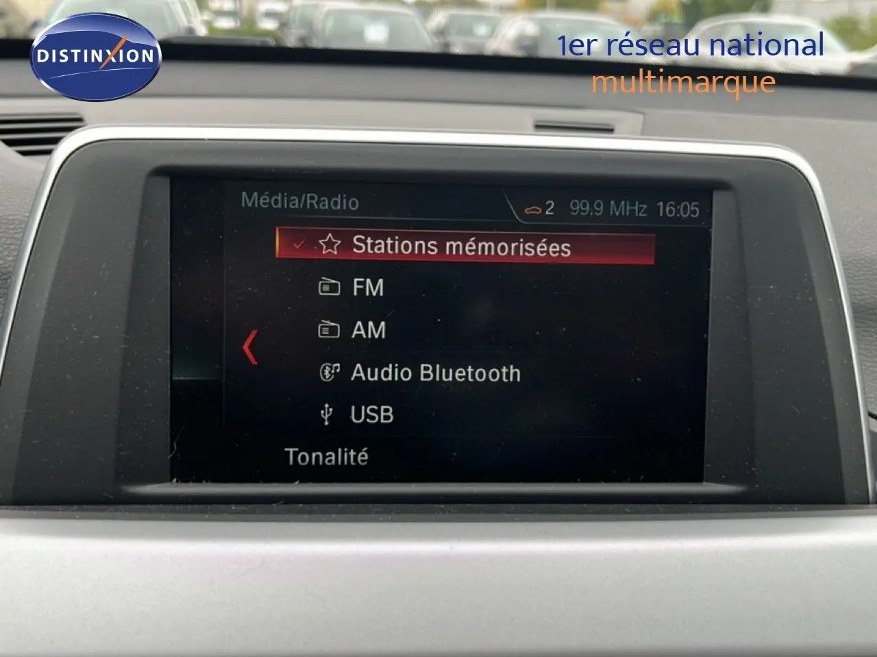 Écran multimédia de BMW X1 18i 2018 affichant les options radio FM, AM, Bluetooth et USB dans un intérieur gris.