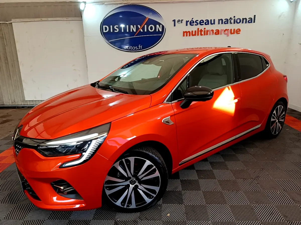 Renault Clio Initiale Paris orange vue 3/4 avant droit en intérieur avec jantes alliage et phares LED distinctifs