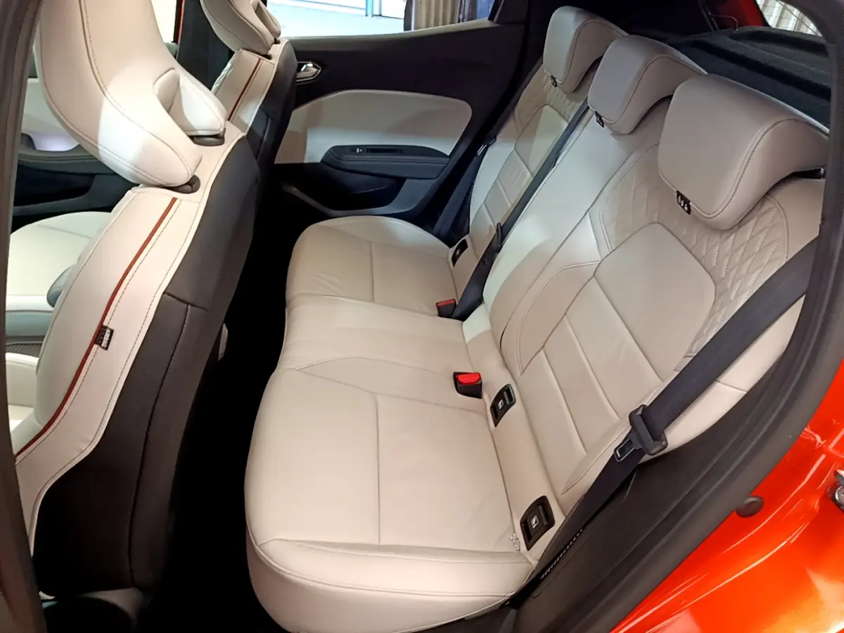 Vue latérale droite des sièges arrière en cuir beige de la Renault Clio Initiale Paris orange 2021, avec ceinture noire.
