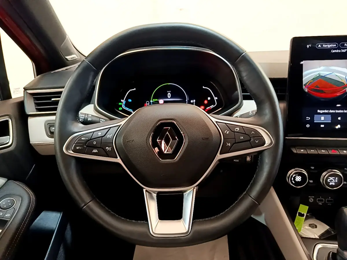 Vue intérieure centrée sur le volant cuir noir et le tableau de bord numérique de la Renault Clio Initiale Paris E-TECH 2021.