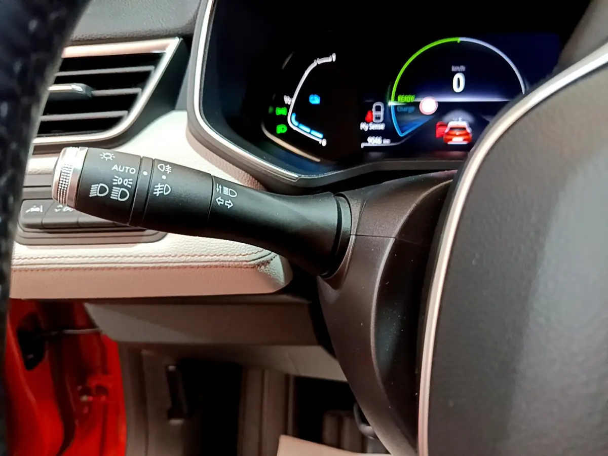 Gros plan sur le commodo gauche et le tableau de bord numérique d'une Renault Clio Initiale Paris orange 2021.