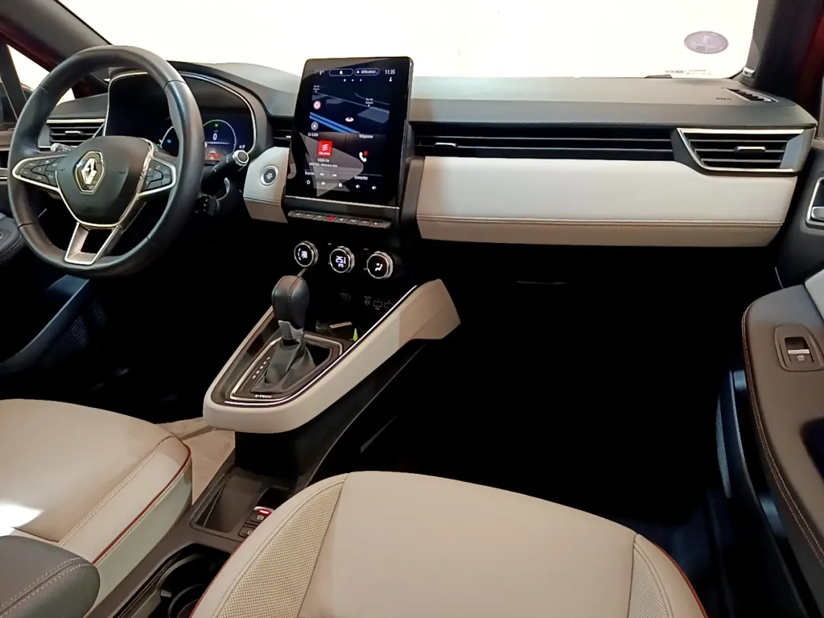 Intérieur clair de Renault Clio Initiale Paris 2021, vue côté conducteur avec écran tactile vertical et volant cuir noir.